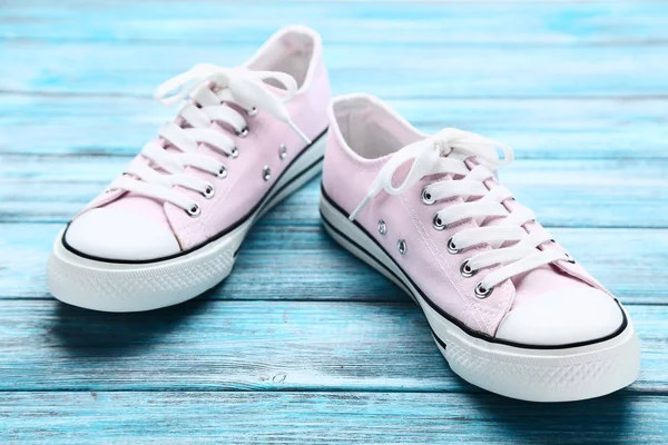 Par i rosa sneakers på blått träbord — Stockfoto