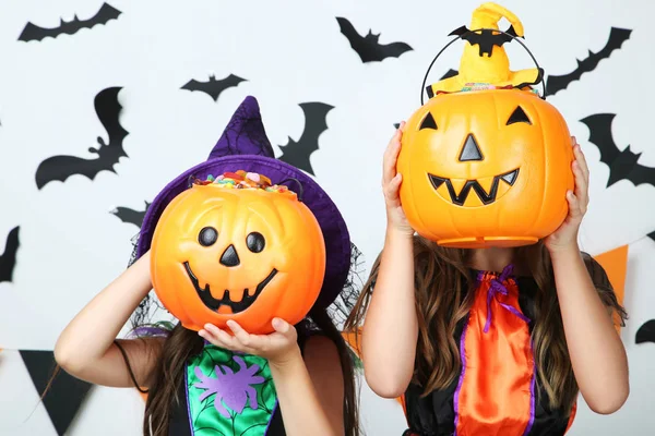 Due giovani ragazze in costumi di Halloween con secchi di zucca su wh — Foto Stock