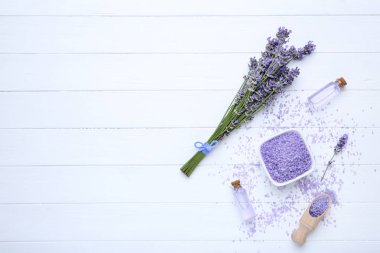 Beyaz ahşap ta üzerinde şişe ve tuz yağ ile Lavanta çiçekleri