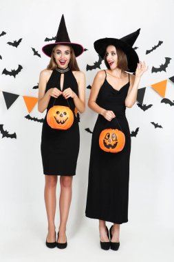 Beyaz kabak kovaları ile siyah kostümleri iki genç kadın 