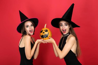 Kırmızı cadılar bayramı balkabağı ile siyah kostümleri iki genç kadın 