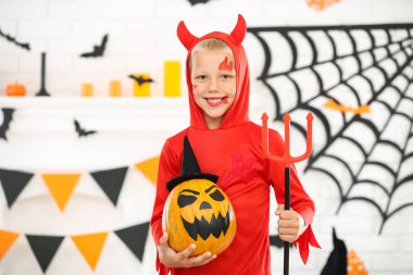 Turuncu balkabağı ile cadılar bayramı kostümü genç çocuk