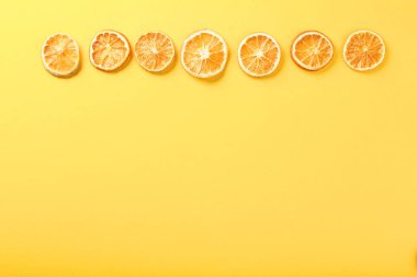 Sarı arka planda kurutulmuş portakal meyveleri