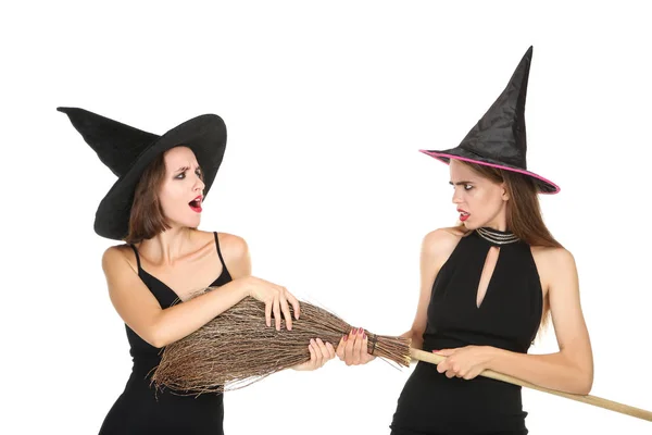 Duas jovens mulheres em trajes de Halloween preto com vassoura em branco — Fotografia de Stock