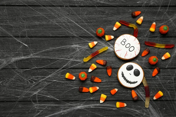 Halloween mézeskalács sütik cukorka, fekete fából készült asztal — Stock Fotó