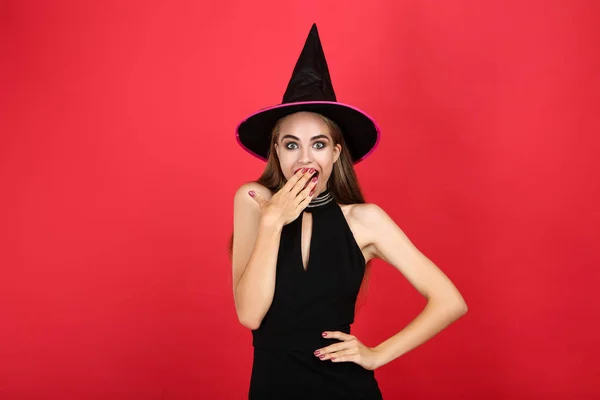 Bela mulher surpreso em traje de Halloween no fundo vermelho — Fotografia de Stock