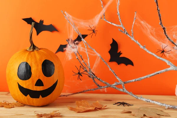 Zucca di Halloween con pipistrelli di carta, foglie secche e ramo d'albero su — Foto Stock