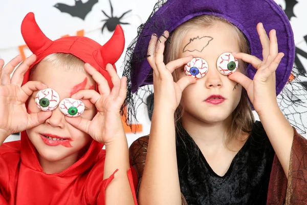 Jong meisje en jongen in Halloween kostuums houden van witte ogen — Stockfoto