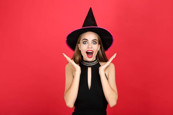 Mooie verrast vrouw in Halloween kostuum op rode achtergrond — Stockfoto