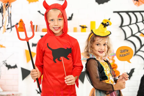 Young girl and boy in costumes holding paper cat and text Happy