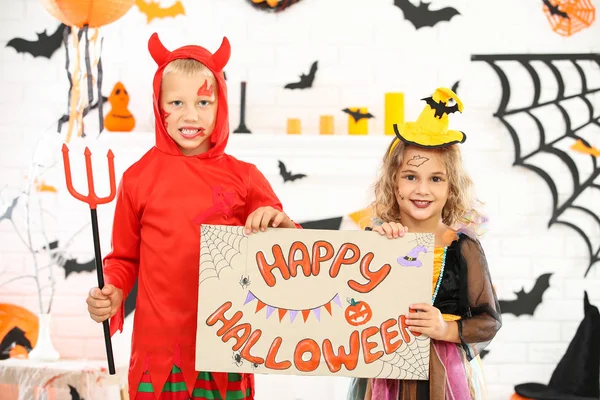 Young girl and boy in costumes holding paper with text Happy Hal — Stock Photo, Image