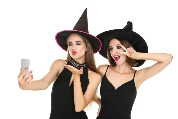 Дві молоді жінки в чорних костюмах на Хеллоуїн роблять селфі на мак — стокове фото