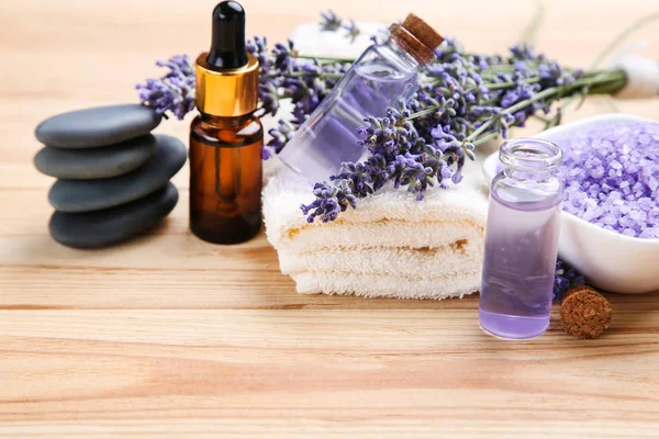 Lavendelblüten mit Öl in der Flasche, Salz und Wellness-Steinen auf der Stirn — Stockfoto
