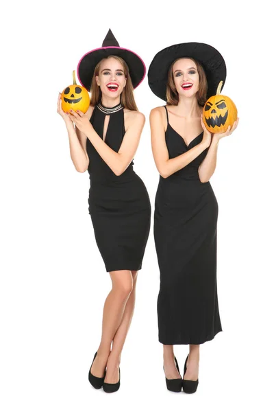 Twee jonge vrouwen in zwarte kostuums houden Halloween pompoenen op — Stockfoto