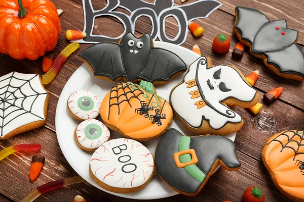 Halloween gingerbread cookies with candies in plate on brown woo — Stock Photo, Image