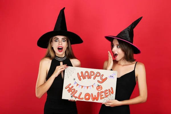 Dvě mladé ženy v černých kostýmech s textem Happy — Stock fotografie