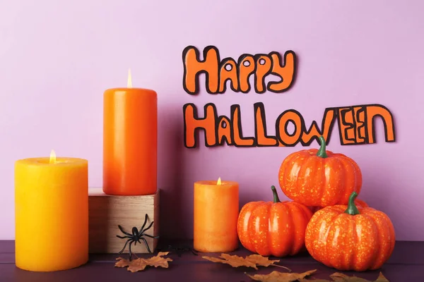 Tekst Happy Halloween met kaarsen, pompoenen en droge bladeren op PUR — Stockfoto