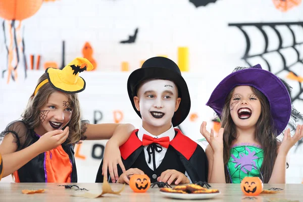 Belle due ragazze e ragazzo in costumi di Halloween seduti vicino al — Foto Stock