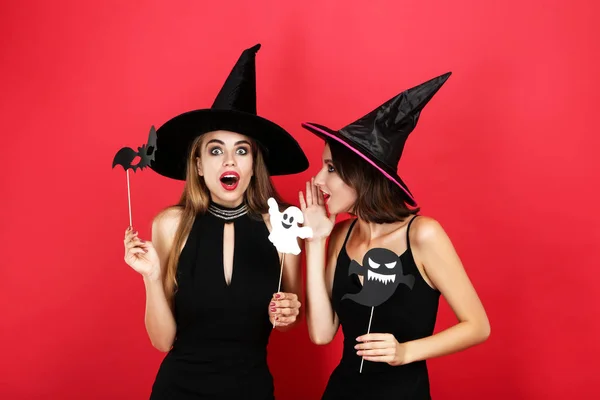 Dos mujeres jóvenes en trajes de halloween con murciélago de papel y fantasma o —  Fotos de Stock