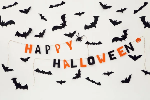 Paper halloween bats and text Happy Halloween on white backgroun
