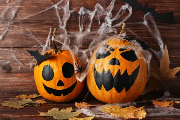 Halloween pumpor med torra Leafs och Spiderweb Software på trä bakgr — Stockfoto