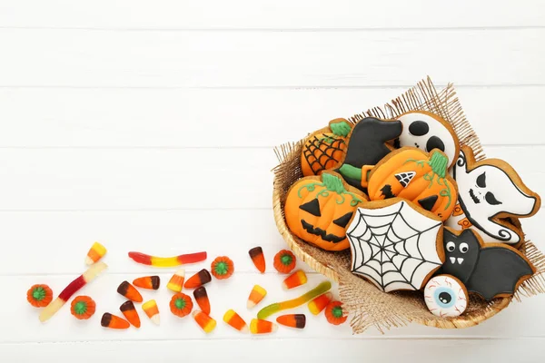 Biscuits au pain d'épice Halloween avec des bonbons sur une table en bois blanc — Photo