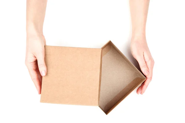 Manos femeninas abriendo caja de regalo marrón sobre fondo blanco — Foto de Stock