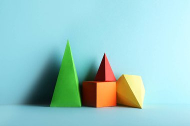 Mavi arkaplanda renkli kağıt geometrik şekiller