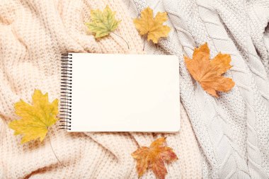 Sonbahar yapraklı ve boş kağıtlı yün kazaklar.