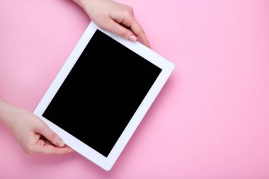 Pembe arka planda kadın ellerde tablet bilgisayar