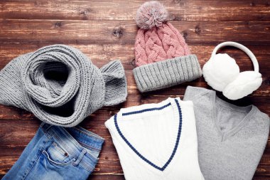 Şapkalı, atkılı, kulaklıklı ve ahşap pantolonlu örülmüş bir kazak.