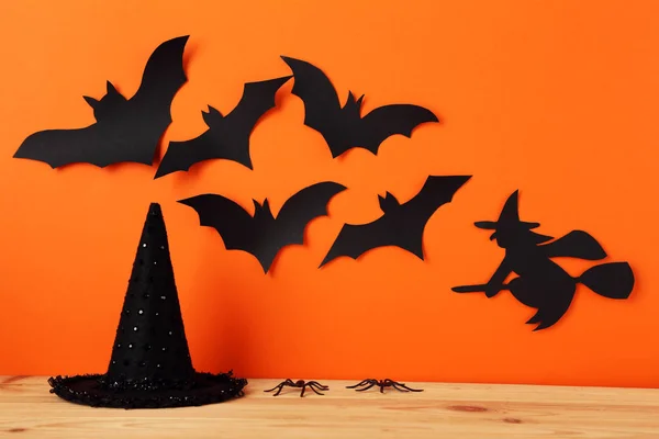 Chauves-souris halloween en papier, sorcière avec chapeau sur fond orange — Photo