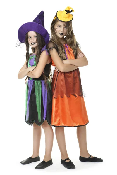 Twee jonge meisjes in halloween kostuums op witte achtergrond — Stockfoto