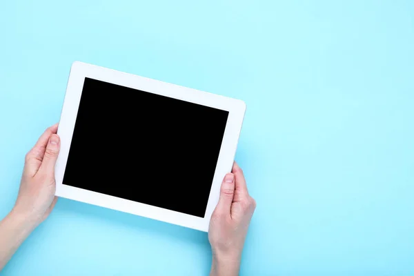Tablet υπολογιστή σε γυναικεία χέρια σε μπλε φόντο — Φωτογραφία Αρχείου