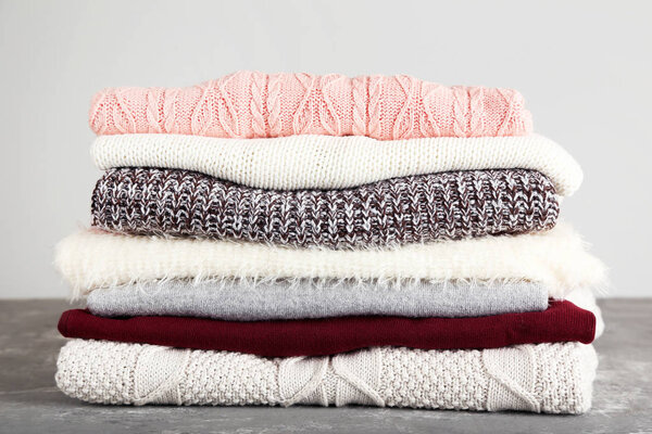 Складные вязаные свитера на сером фоне
