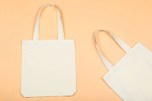 Білі бавовняні екологічні сумки на бежевому фоні — стокове фото