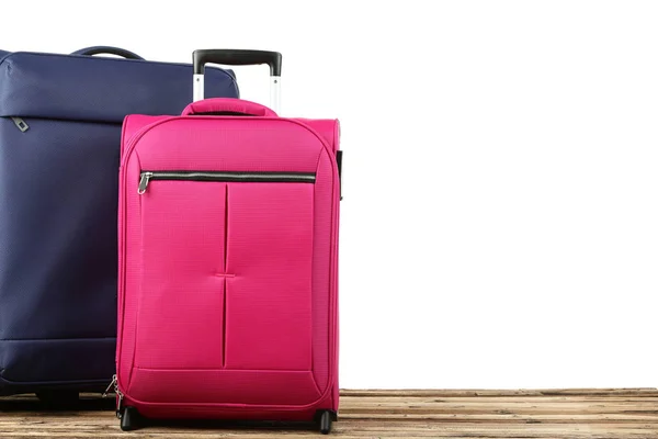Blauwe en roze koffers op houten tafel — Stockfoto