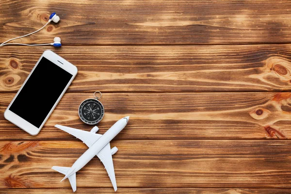 Modelo de avión con smartphone, brújula y auriculares en marrón w — Foto de Stock