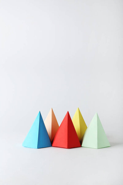 Цветные геометрические фигуры бумаги на сером фоне
