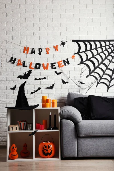 Хэллоуин украшения с бумажными летучими мышами, паутина рядом с серым диваном — стоковое фото