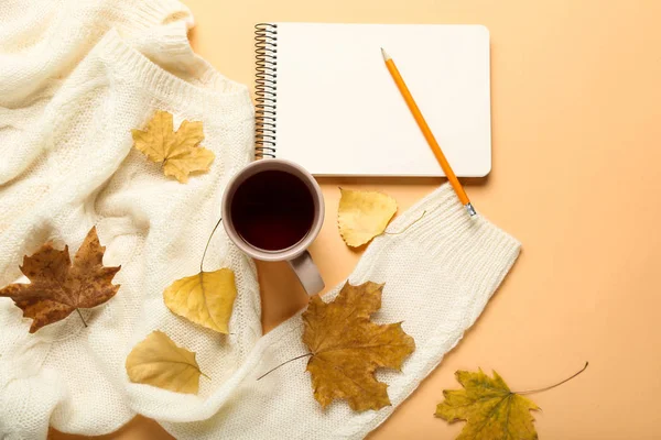 Pull en laine avec feuilles d'automne, bloc-notes et tasse de thé sur beig — Photo