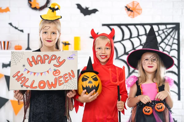 Chicas jóvenes y niño en trajes con cubos de calabaza y texto Ha —  Fotos de Stock