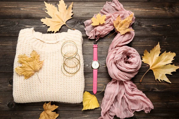 Wollen trui met sjaal, polshorloge en herfstblaadjes op bruin — Stockfoto