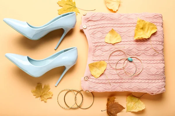 Wollpullover mit hochhackigen Schuhen, Armbändern und Herbstblatt — Stockfoto
