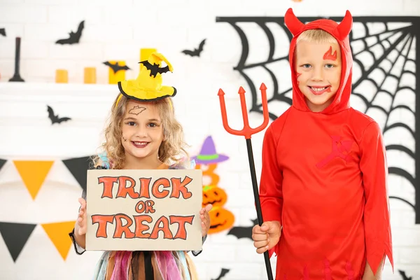 Niña y niño en trajes de Halloween y papel con texto Tri —  Fotos de Stock