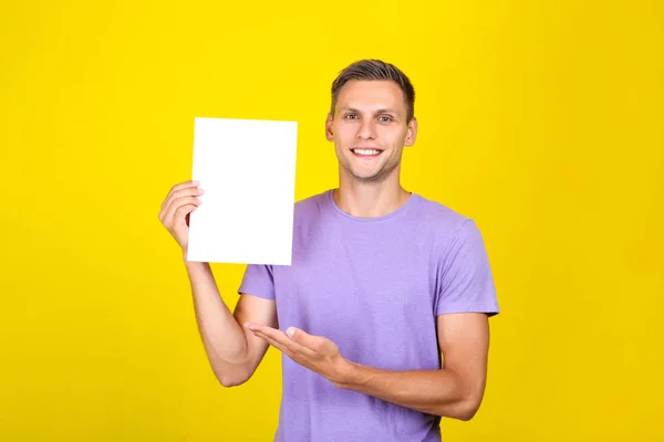 Jovem com placa em branco no fundo amarelo — Fotografia de Stock