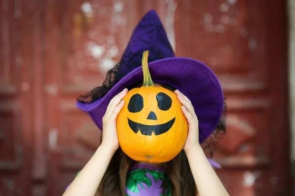 Mooi meisje in Halloween kostuum houden pompoen — Stockfoto