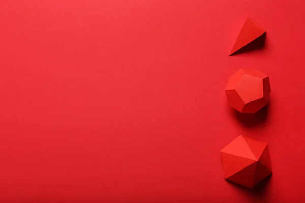 Figuras geométricas de papel sobre fondo rojo —  Fotos de Stock