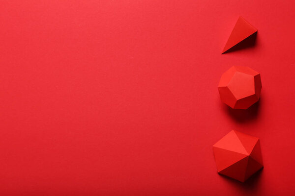 Paper geometric figures on red background