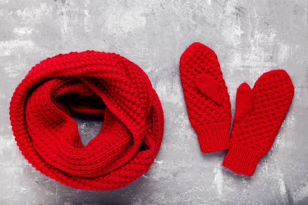 Knitted red scarf and pair of gloves on grey background — Stock Photo, Image